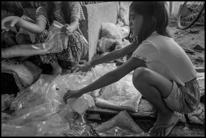 A girl in the Compostela Valley flattens plastic sheets coated with Lorsban.